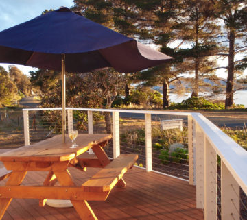 The deck of Carrington Cottage looks out to the beach immediately across the road.